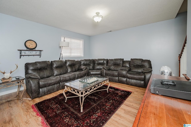 living room with wood-type flooring and a textured ceiling