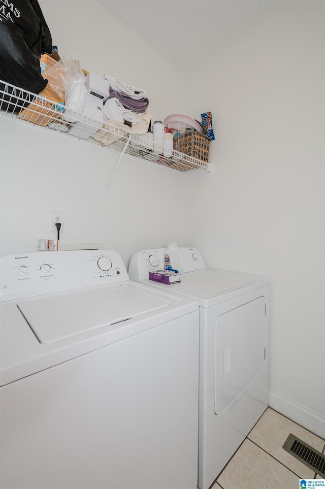 laundry area featuring light tile patterned flooring and washing machine and clothes dryer