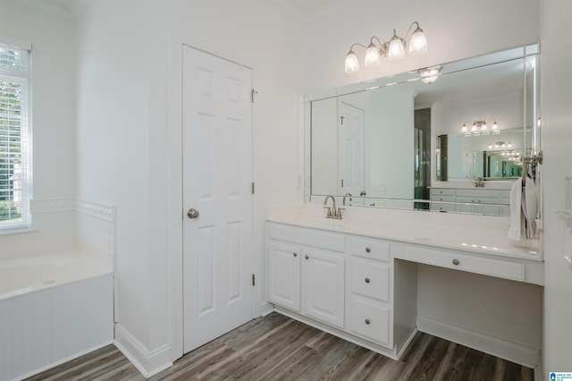 bathroom featuring ornamental molding, a tub to relax in, wood-type flooring, and vanity