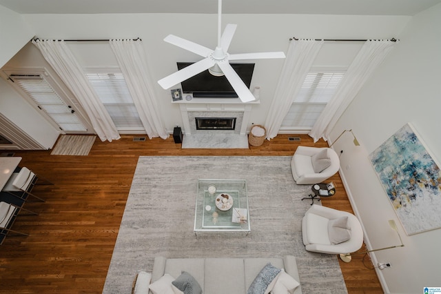 living room with dark hardwood / wood-style flooring, a fireplace, and ceiling fan