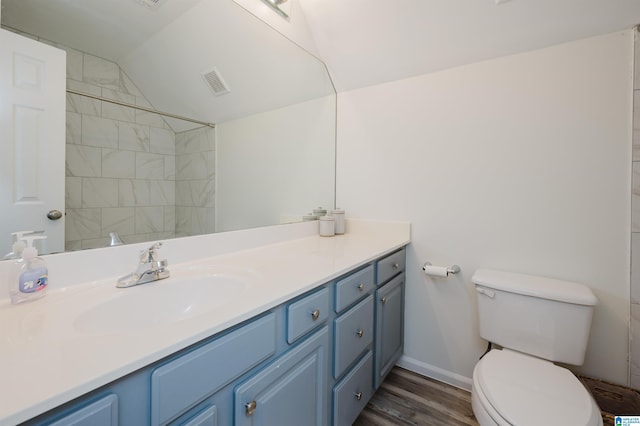 bathroom with vaulted ceiling, hardwood / wood-style floors, vanity, and toilet