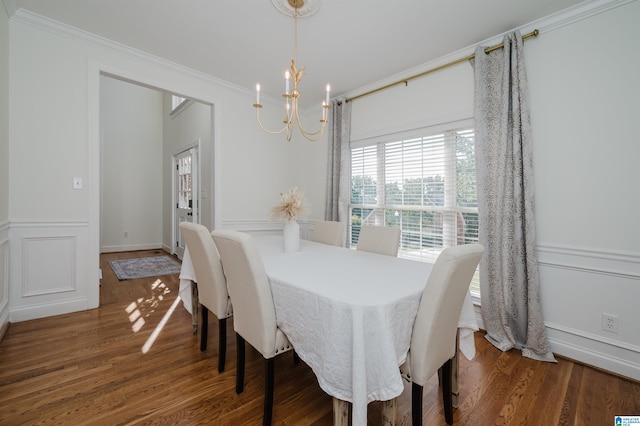 dining room featuring crown molding, dark wood-type flooring, and a chandelier