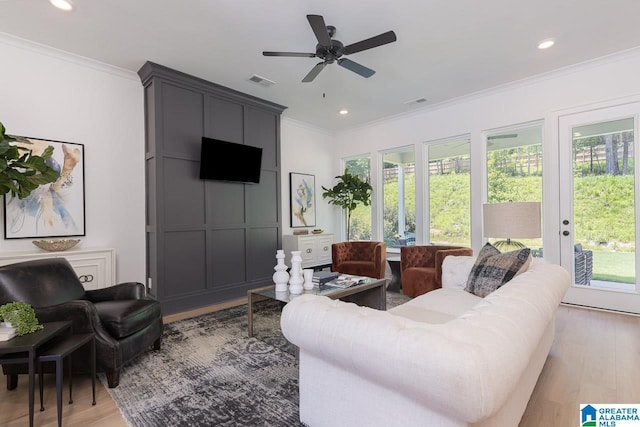 living room with crown molding, ceiling fan, and light hardwood / wood-style flooring