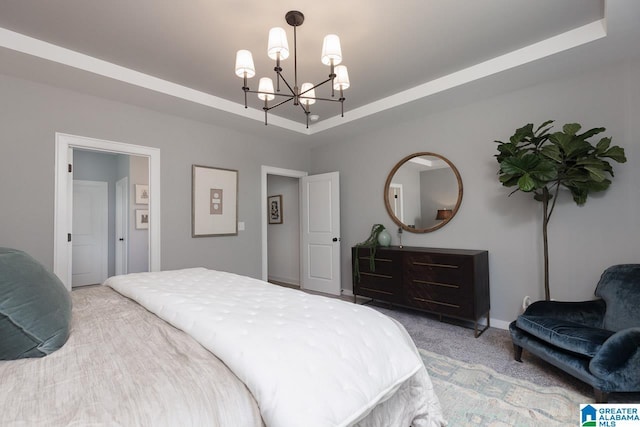 carpeted bedroom with a notable chandelier and a raised ceiling
