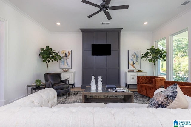 living room with ceiling fan, ornamental molding, and hardwood / wood-style floors