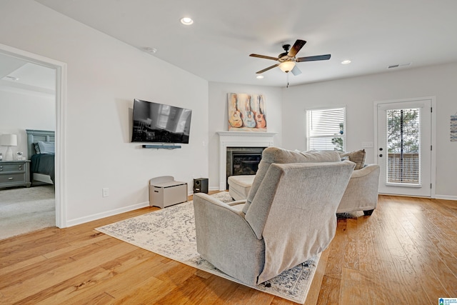 living room featuring ceiling fan and light hardwood / wood-style floors