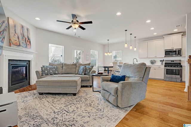 living room featuring ceiling fan and light hardwood / wood-style floors