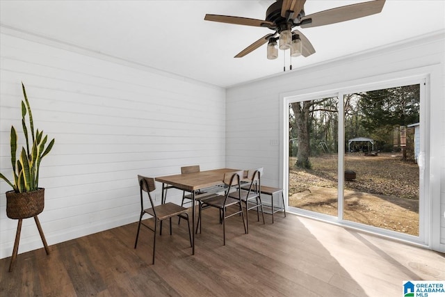 dining space with ceiling fan and wood-type flooring