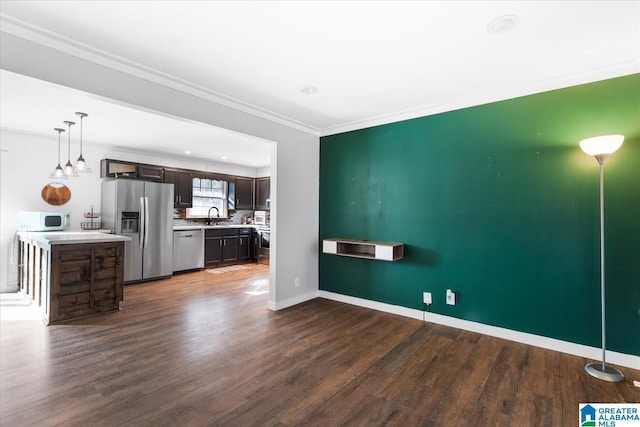 unfurnished living room featuring ornamental molding, dark wood-type flooring, and sink