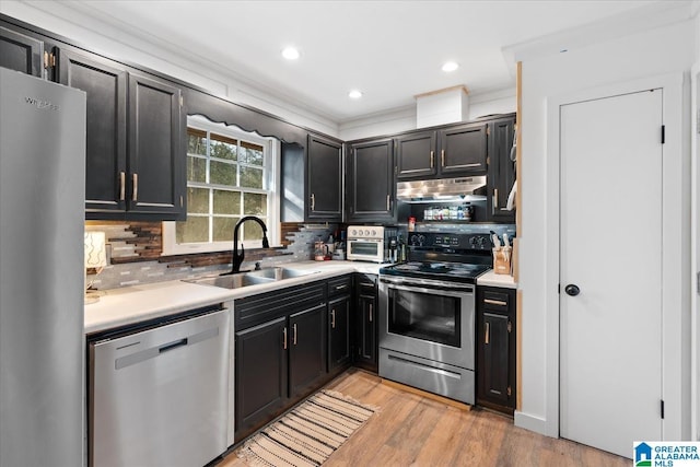 kitchen featuring sink, crown molding, light hardwood / wood-style flooring, appliances with stainless steel finishes, and backsplash