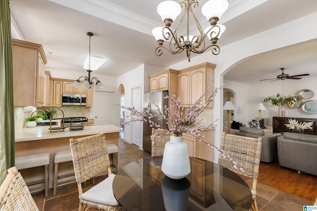 dining space featuring dark hardwood / wood-style flooring, crown molding, and ceiling fan with notable chandelier