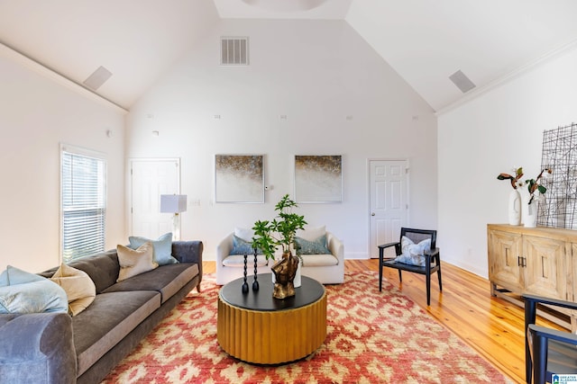 living room with crown molding, hardwood / wood-style flooring, and high vaulted ceiling