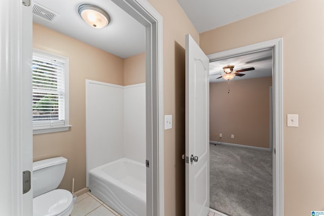 bathroom featuring tile patterned flooring, a bathing tub, ceiling fan, and toilet