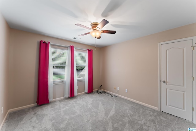 carpeted spare room featuring ceiling fan