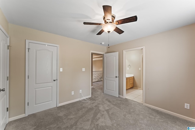 unfurnished bedroom with connected bathroom, light colored carpet, and ceiling fan