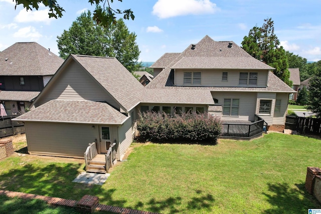 rear view of property with a wooden deck and a yard