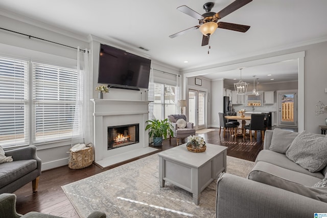 living room with hardwood / wood-style floors, ornamental molding, a wealth of natural light, and ceiling fan