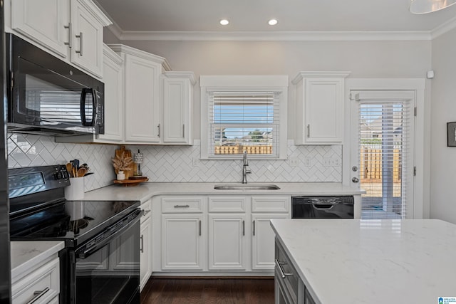 kitchen with sink, white cabinets, light stone counters, and black appliances