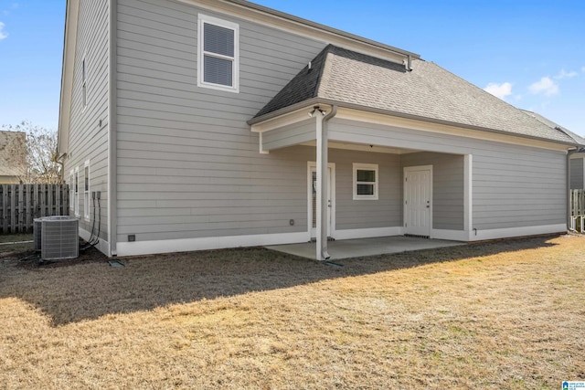 rear view of property with central AC, a patio, and a lawn