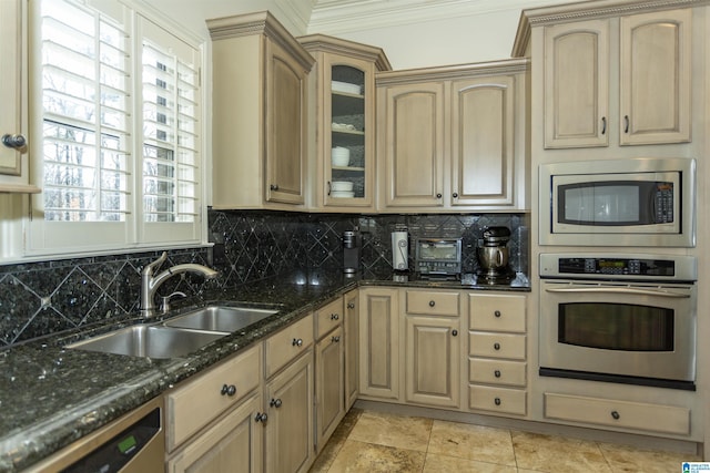 kitchen with sink, dark stone countertops, ornamental molding, appliances with stainless steel finishes, and backsplash