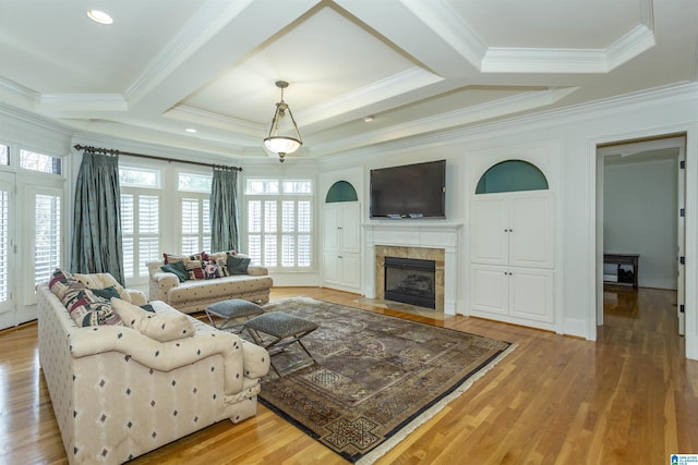 living room with a tiled fireplace, crown molding, light hardwood / wood-style floors, and beamed ceiling