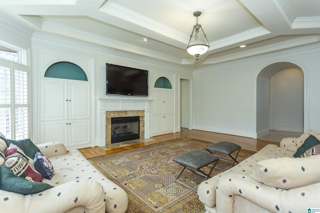 living room featuring crown molding, a premium fireplace, and hardwood / wood-style floors