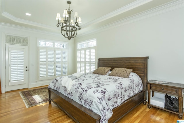 bedroom with crown molding, light hardwood / wood-style flooring, and a notable chandelier