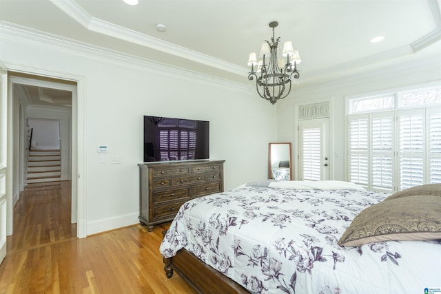 bedroom with ornamental molding, a chandelier, and light wood-type flooring