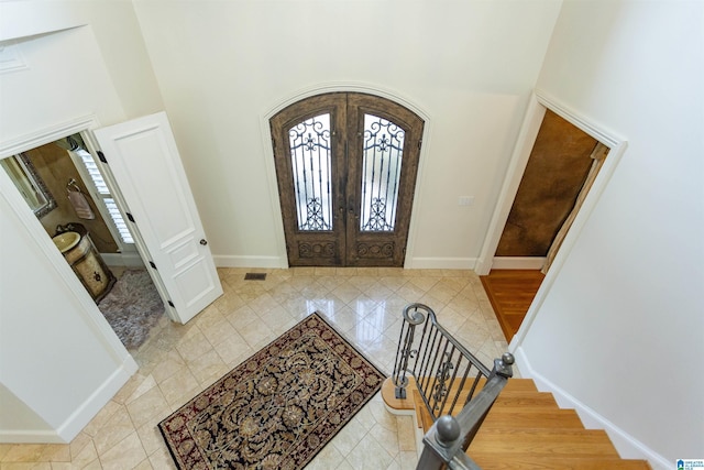 entryway featuring a towering ceiling and french doors