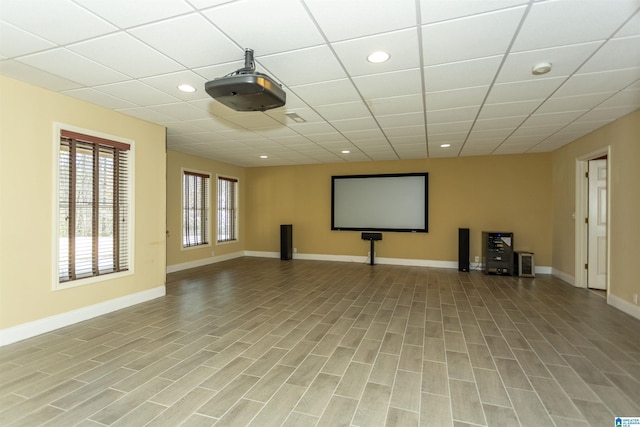 cinema featuring light hardwood / wood-style flooring and a drop ceiling