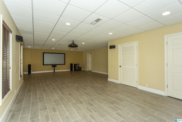 basement with a drop ceiling and light wood-type flooring