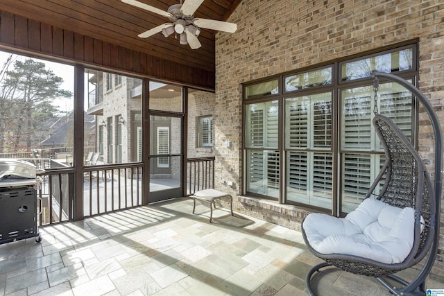 sunroom with lofted ceiling, wood ceiling, and ceiling fan