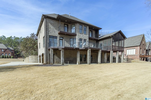 back of house with a sunroom and a lawn