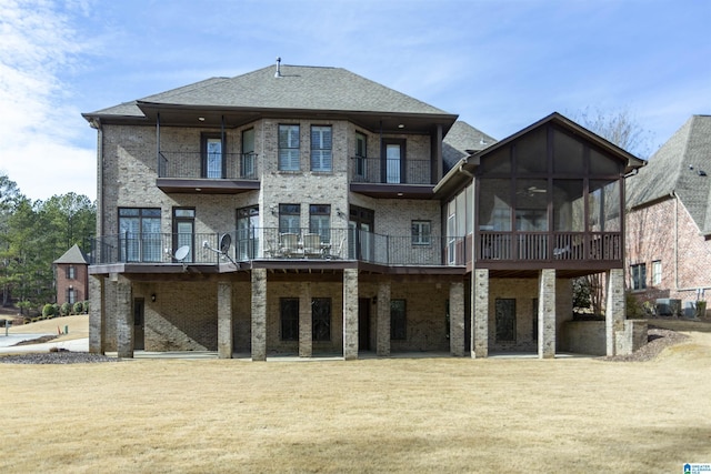 rear view of property with a yard and a sunroom