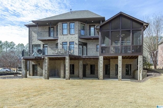 rear view of property featuring a sunroom and a lawn