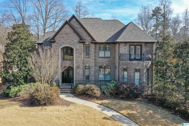 view of front of house featuring a balcony and a front yard