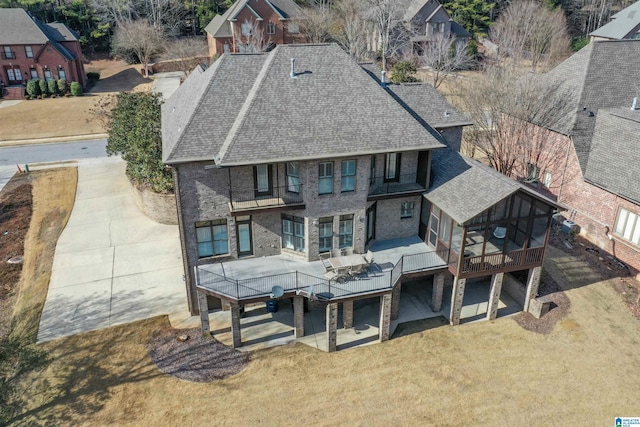 exterior space with a wooden deck, a lawn, and a sunroom