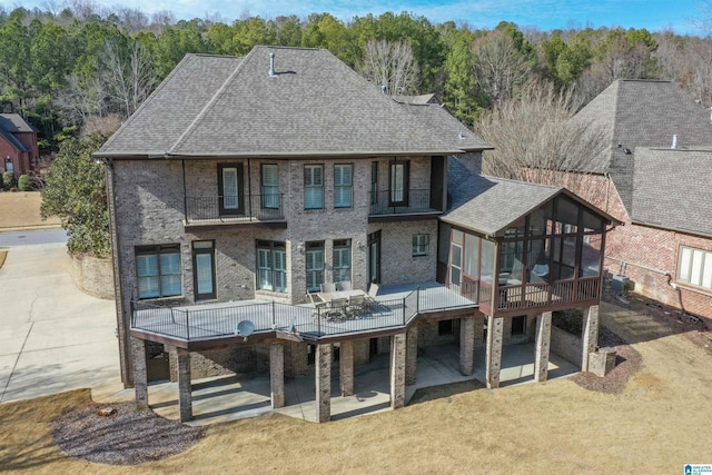 rear view of house featuring a sunroom and a patio