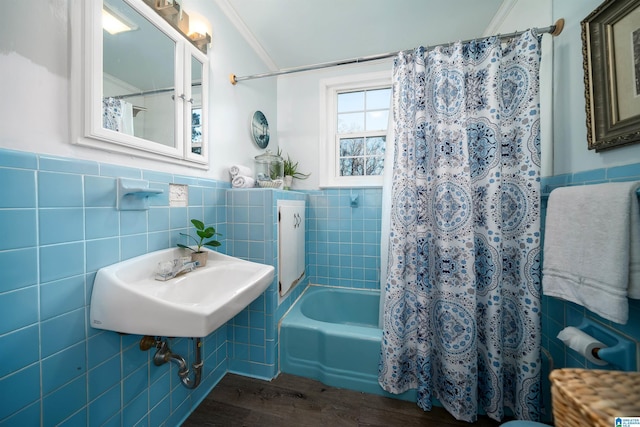 bathroom featuring hardwood / wood-style flooring, ornamental molding, tile walls, and shower / tub combo with curtain