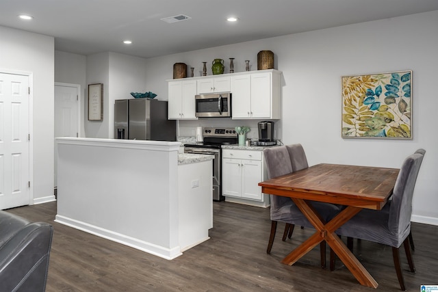 kitchen with white cabinetry, stainless steel appliances, and dark hardwood / wood-style floors