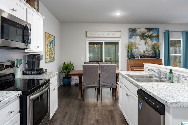 kitchen with stainless steel appliances, white cabinetry, sink, and dark hardwood / wood-style floors