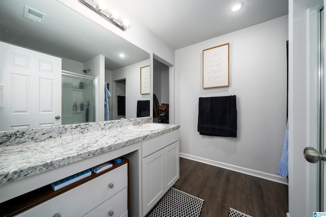 bathroom with hardwood / wood-style flooring, vanity, and a shower with shower door