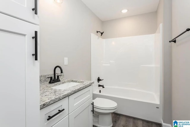 full bathroom featuring vanity, hardwood / wood-style flooring, shower / washtub combination, and toilet