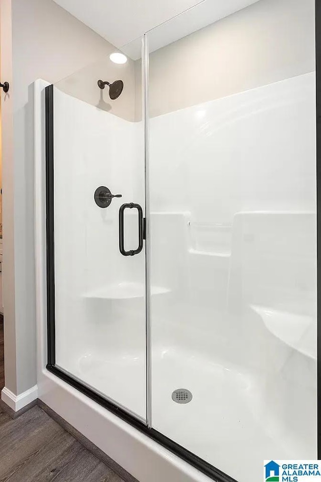 bathroom featuring a shower with door and hardwood / wood-style flooring