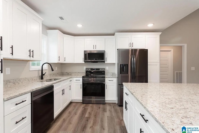 kitchen with white cabinetry, sink, hardwood / wood-style floors, and appliances with stainless steel finishes