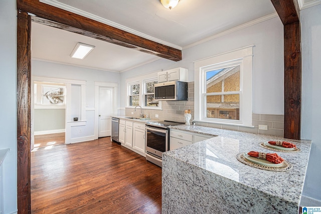 kitchen featuring light stone counters, white cabinetry, tasteful backsplash, and stainless steel appliances