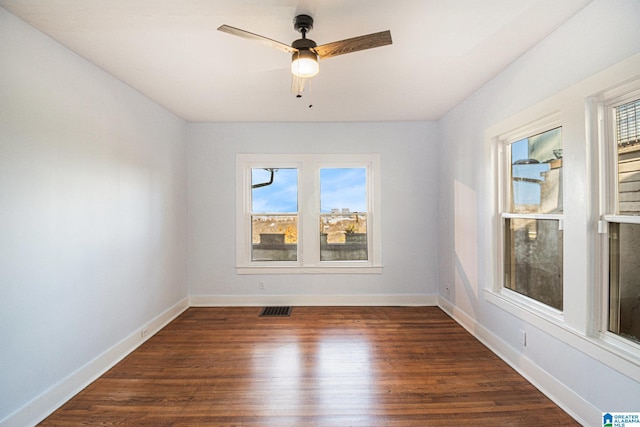 spare room featuring ceiling fan, plenty of natural light, and dark hardwood / wood-style flooring