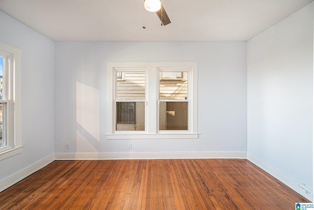 empty room with ceiling fan and dark hardwood / wood-style floors