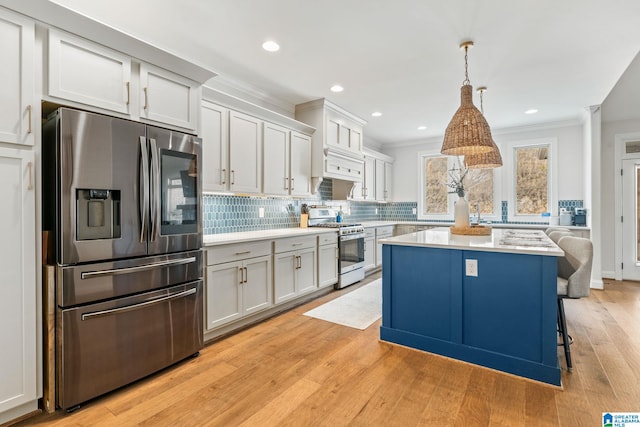 kitchen with a kitchen island, pendant lighting, tasteful backsplash, white cabinetry, and stainless steel appliances