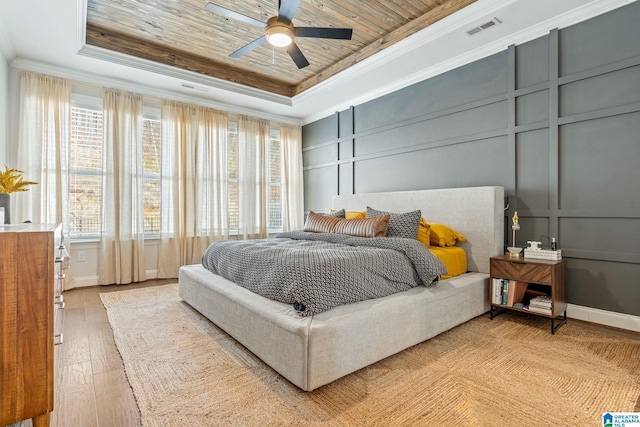 bedroom featuring a raised ceiling, crown molding, wood ceiling, and light hardwood / wood-style flooring